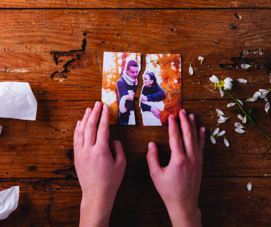 Unrecognizable sad woman holding torn picture of couple in love.